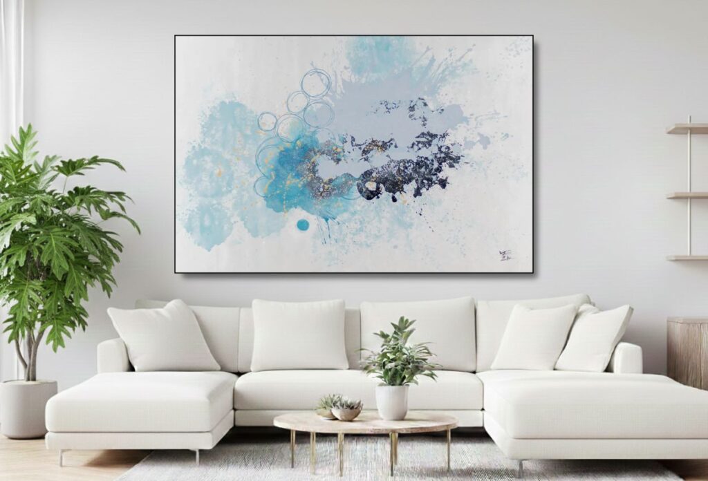 Abstract watercolor blue and purple painting above sofa – A bright living room with a white sofa, a minimalist coffee table, and a soft watercolor-style painting in shades of blue and purple on the wall behind it.